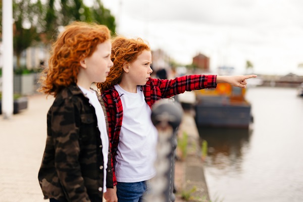 Two children pointing out at water