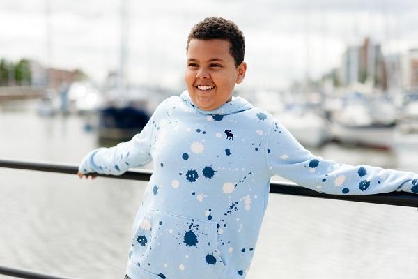 Child in a blue hoody in front of water